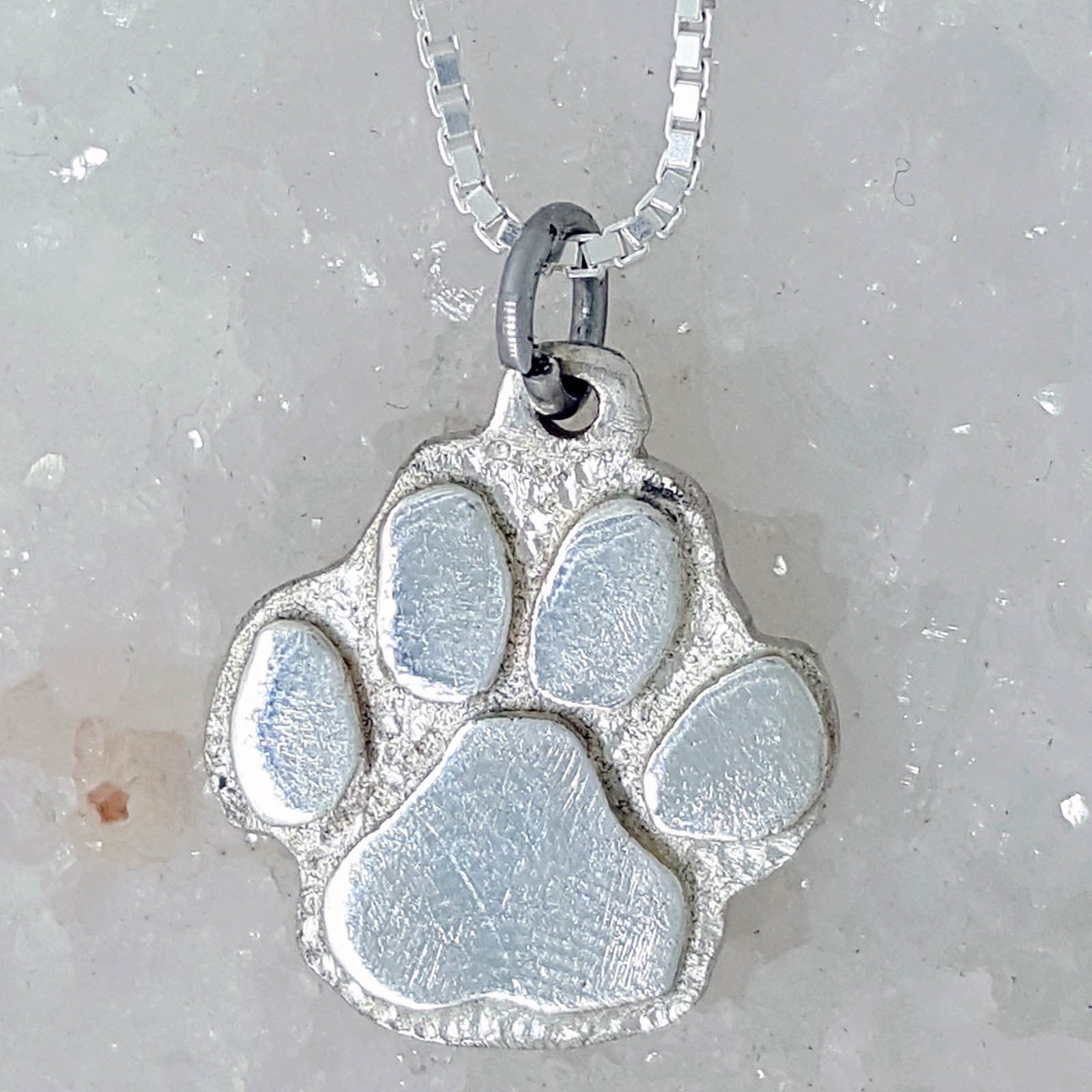 Silver paw print on a pebble necklace | Julia Brice Designs